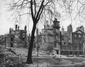 Debris in the Temple, with a tree in the foreground and destroyed buildings behind