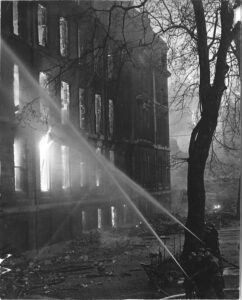 Firefighters spraying a burning building with water