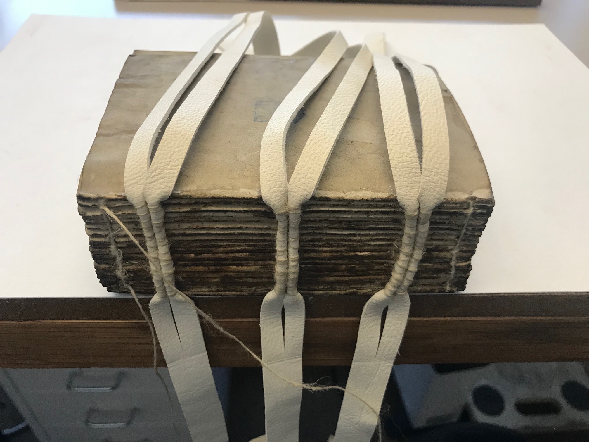three strands of material draped over the book