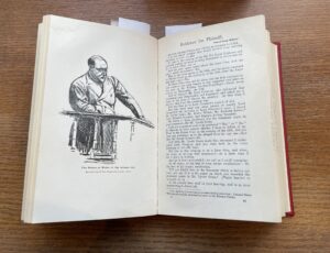 An open book with a black & white drawing of a man one side and text the other.