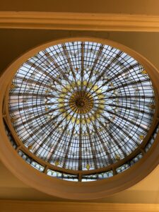 Round stained glass window with lines and circles mainly yellow