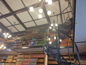 Wall of bookshelves with a metal spiral staircase