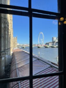 Side of the House of Lords building looking towards the Thames and the London Eye big wheel in the background.
